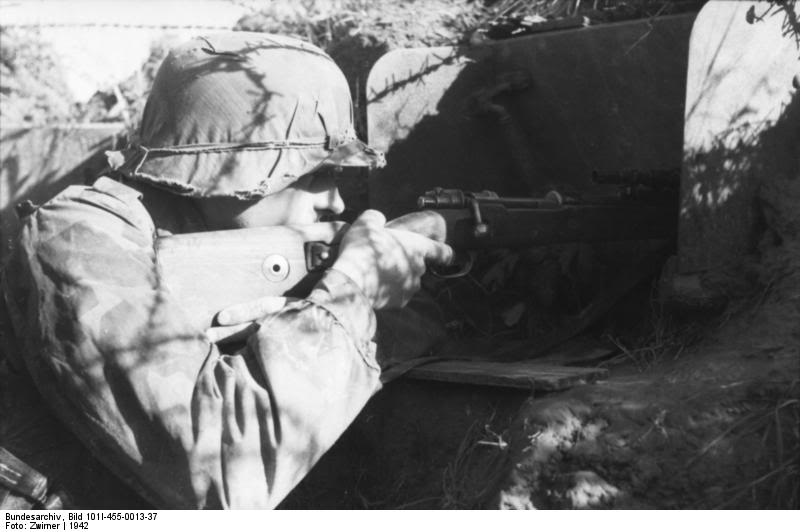 Francotirador alemán al acecho tras el parapeto de una trinchera, se puede ver el cerrojo del Kar98K