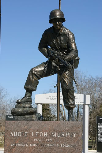 La otra estatua de Murphy recrea el momento en que asaltó varias posiciones alemanas en solitario armado con una MG-42 cerca de St. Tropez, Francia. Se encuentra en el Museo Audie Murphy en Greenville, Texas