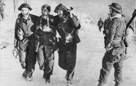 Soldados ingleses se retiran de la zona de lucha, llevando consigo a los heridos