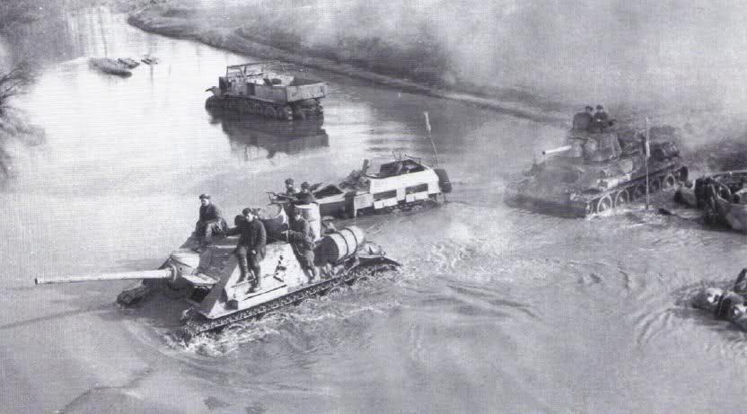 Tropas soviéticas cruzando un rio repleto de vehículos abandonados por los alemanes