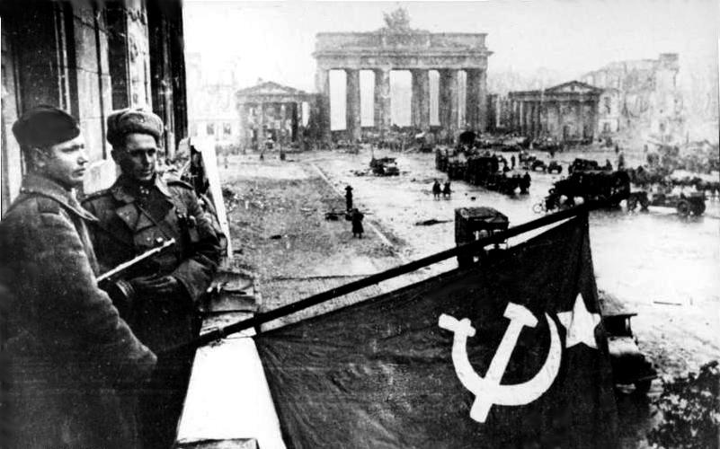 Soldados soviéticos izan la bandera de la Unión Soviética en un balcón del Hotel Adlon, junto a la Puerta de Brandeburgo