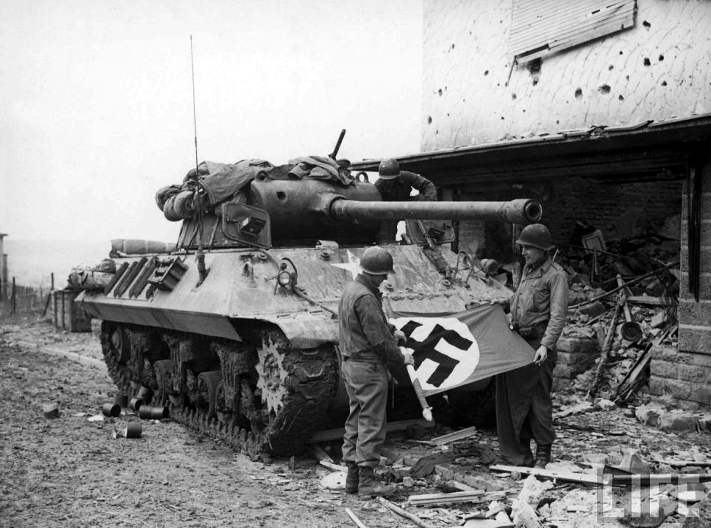 La tripulación de un M-36 enrollando una bandera nazi como trofeo, Bitberg, Alemania