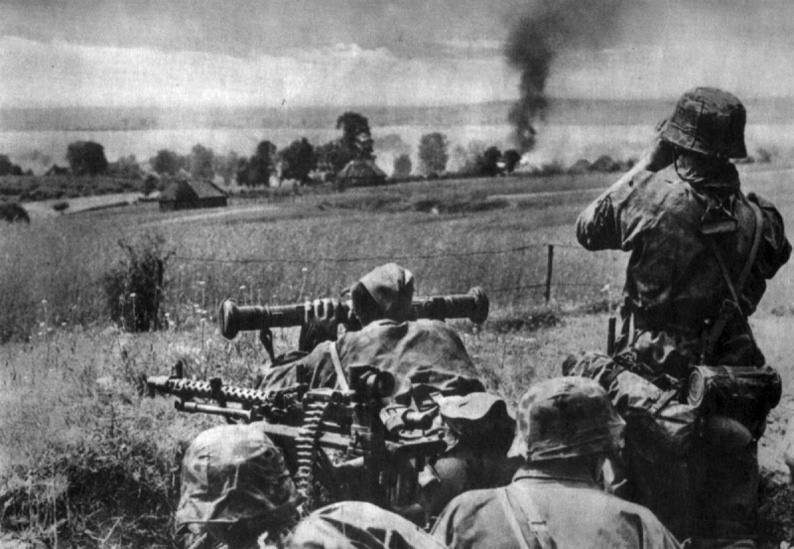 Sirvientes de una Mg 34 de la División SS Leibshtandarte Adolf Hitler observan una aldea en llamas con binoculares y telémetro. URSS, 1941