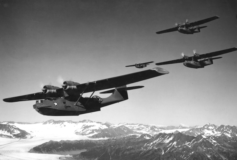 Varios PBY-5 de la Armada de los Estados Unidos sobrevolando un glaciar en la costa de Alaska en agosto de 1942 durante la Batalla de las Islas Aleutianas