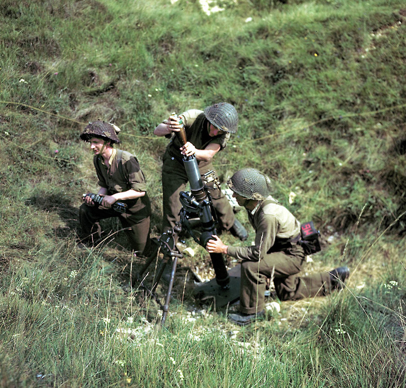 Tres soldados canadienses posan para un fotógrafo de guerra junto a un mortero