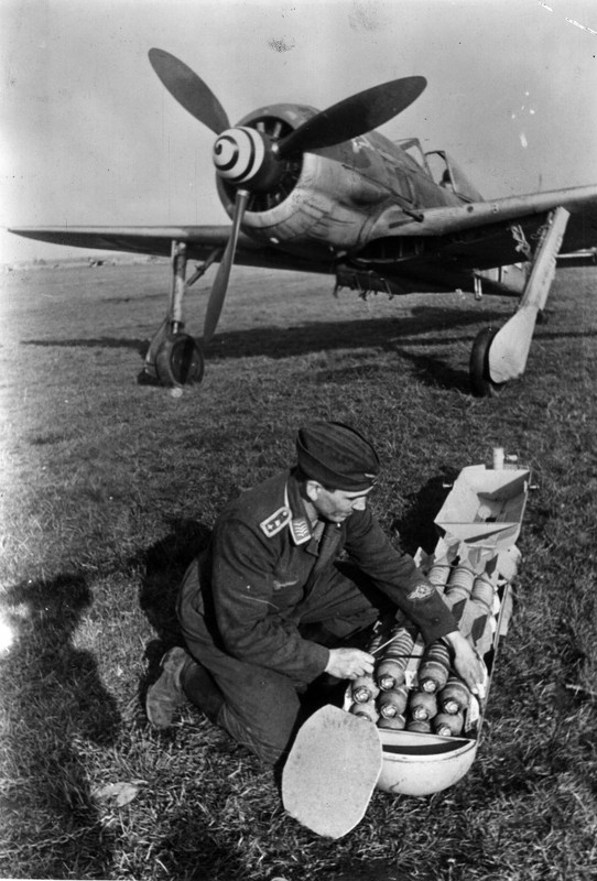 Un técnico de aviación alemán prepara una bomba de racimo para un Focke-Wulf Fw 190F