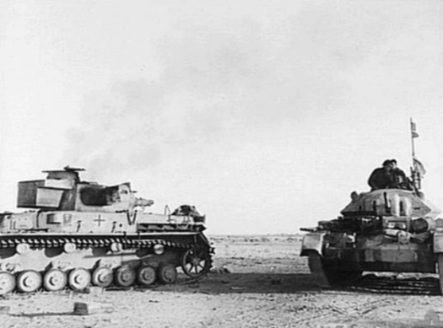 Un Crusader pasa al lado de un Panzer alemán destruido