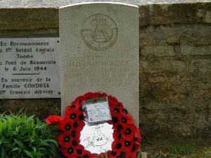 Tumba del teniente Danny Brotheridge en el cementerio de la iglesia de Bénouville. La placa conmemorativa situada tras la tumba fue donada por la familia Gondreé, dueña del famoso Café Gondreé