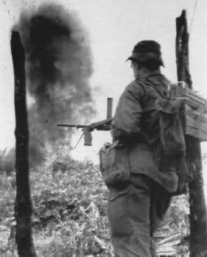 Un soldado del 5 Regimiento Real Australiano, con un subfusil Owen, observa la destrucción de la aldea de Long Tan, en Vietnam