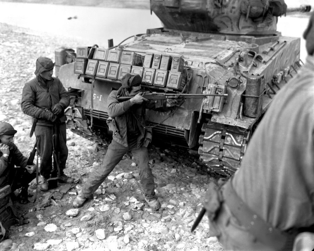 Parapetado detrás de su tanque de escolta, un soldado devuelve el fuego sobre las posiciones chinas con una M1918A2. Corea, 1951