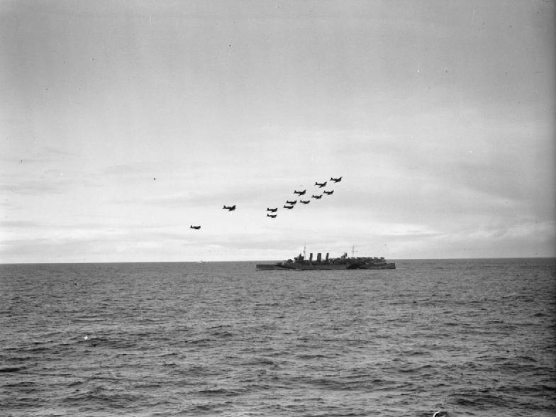 Formación de Trece Chance-Vought Corsairs, pertenecientes al Portaaviones HMS Trumpeter, volando en formación sobre el HMS Kent