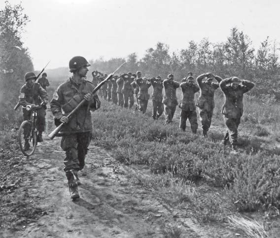 Prisioneros alemanes de la 59ª División de Infantería son escoltados por miembros del 502nd PIR