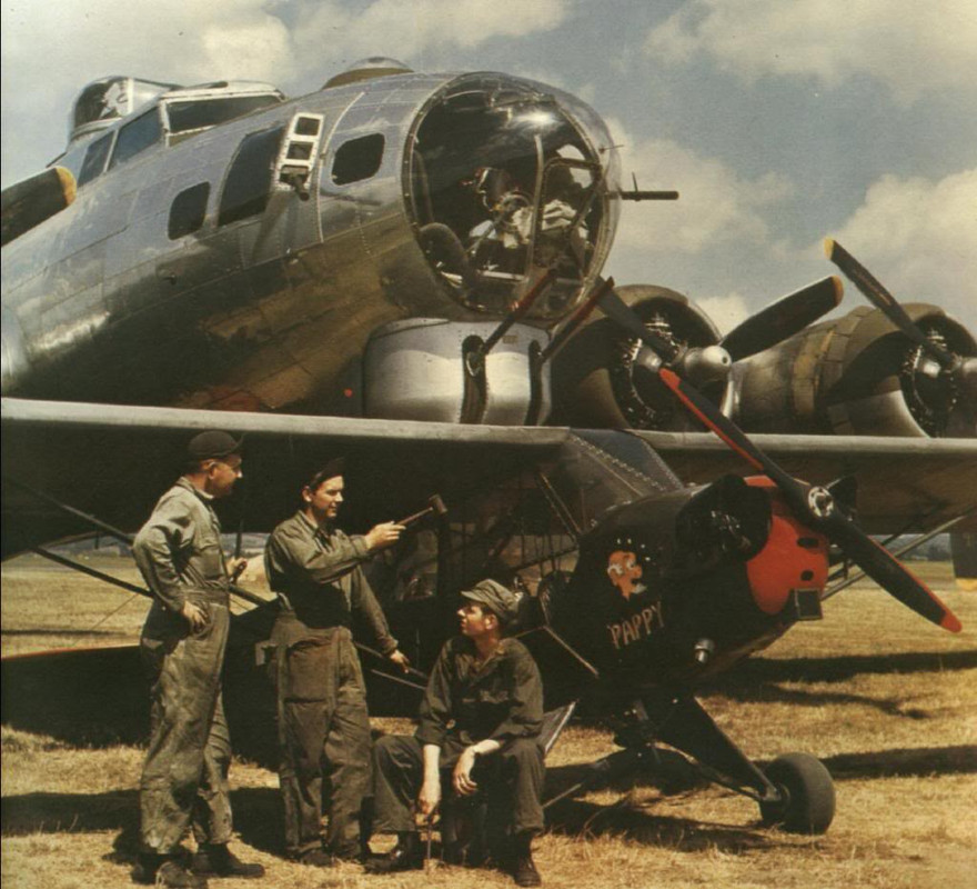 El equipo de tierra de un Piper Cub junto a un Boeing B-17 Flying Fortress, Inglaterra, a mediados de la década de 1940