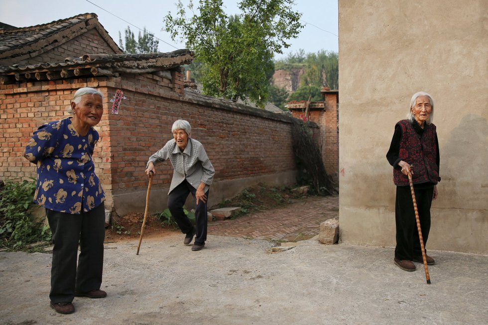 Mujeres del pueblo de Gucheng acompañan a Hao Juxiang, a la derecha, en los alrededores de sus casas. Hao vive en una pequeña comunidad y muchos de sus vecinos conocen su terrible pasado como antigua mujer de solaz
