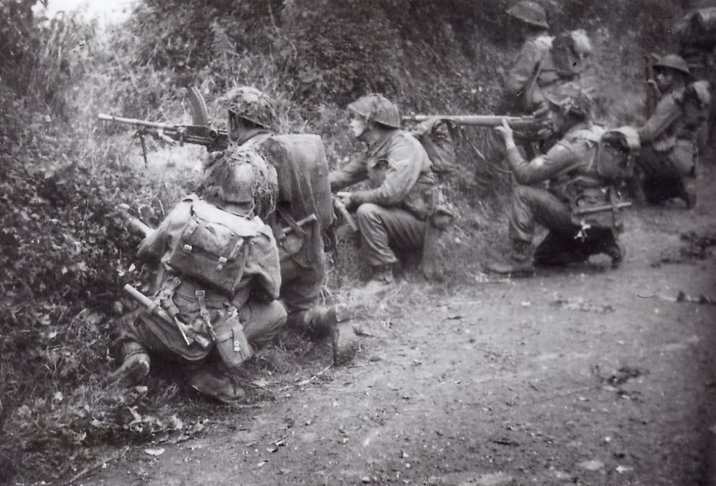 Soldados británicos combatiendo en el bocage normando, julio de 1944. Se puede ver que uno lleva una Bren, y otro un fusil Lee-Enfield Nr 4 Mk I
