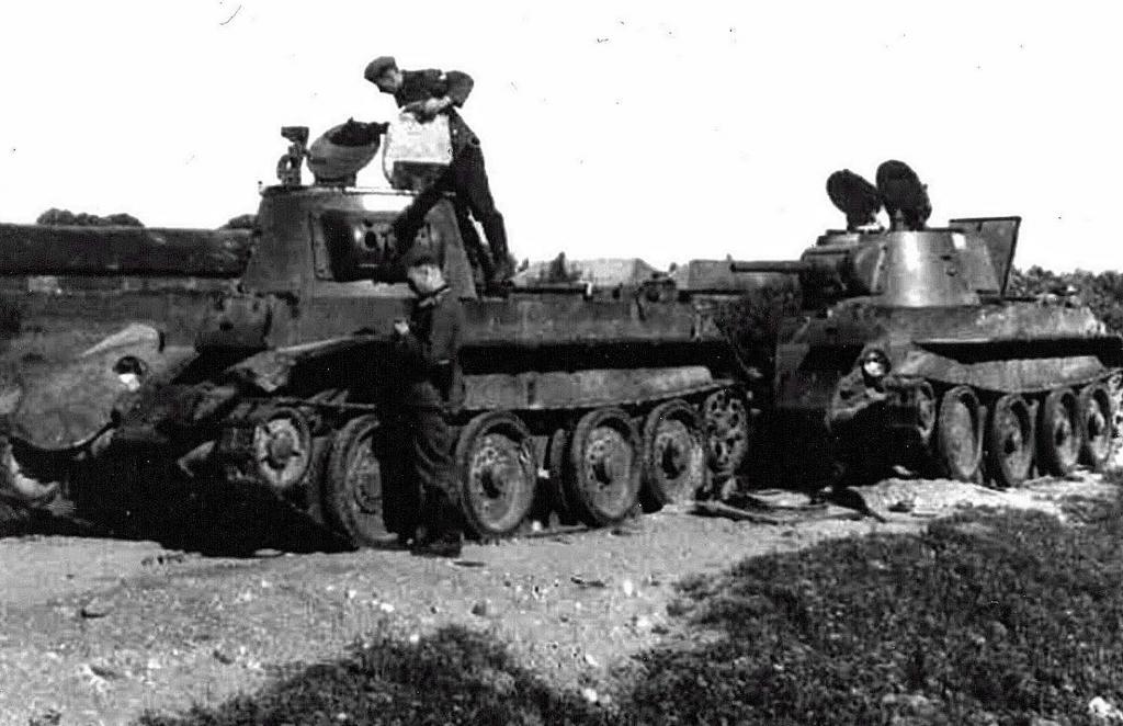 Soldados inspecciona un BT-7 destruido durante la invasión de Rusia